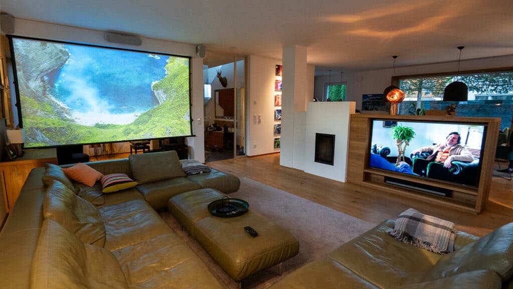 Wohnzimmer mit integriertem Beamer und Leinwand neben dem Fernseher